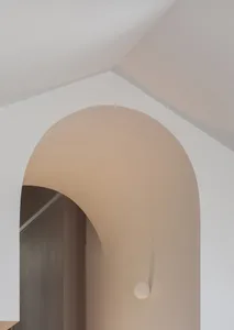 A modern minimalist interior featuring a cement archway.