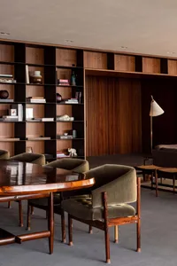 Modern residential interior featuring wooden furniture and a large bookshelf.
