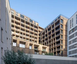 Modern residential building with wooden façade and multiple balconies.