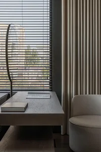A minimalistic modern workstation featuring neutral-colored wood and fabric materials.