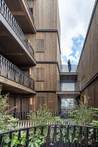 A modern architectural structure featuring wooden construction and balconies.