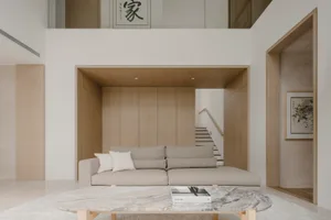 Modern living room with wooden walls, marble coffee table, fabric sofa, and minimalist decorations.