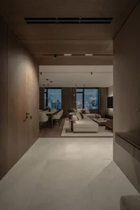 A modern living and dining room with a white marble floor, wooden accents, and large windows overlooking a cityscape.
