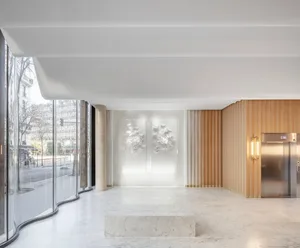 Modernistic lobby interior with white marble floor, glass walls, and contemporary white sculptures