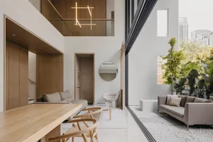 A modern minimalist living room with wood accents, concrete flooring, and glass elements.