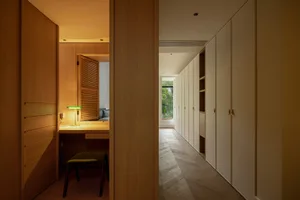 Modern house interior with minimalist design featuring white cabinets and wooden finishes.