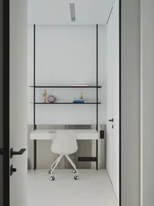 A minimalist white desk with a black metal frame in a minimalist environment.