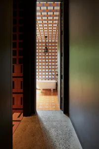 An industrial-style bathroom with a white clawfoot bathtub and patterned tile walls and floor.