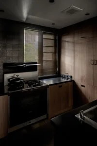 Modern kitchen featuring a black stove and wooden cabinets with a window allowing natural light.