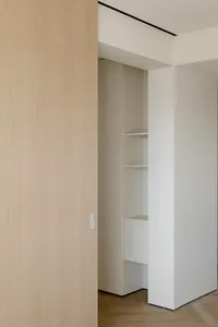 Modern interior design featuring wooden closet storage with shelves and drawers.