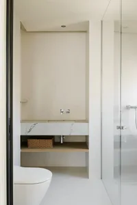 Modern minimalist bathroom with a white marble countertop and white floor tiles.