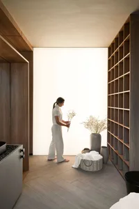 A woman holding flowers in a minimalist residential interior with wooden walls and fabric elements.