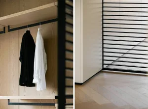 A modern closet with wooden shelves and black metal rods.
