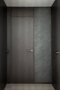 A modern dark door with a black marble core.