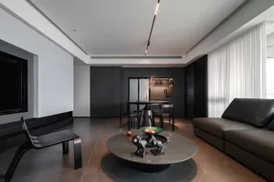 Modern apartment interior designed in black, grey, and white with a minimalist style, featuring furniture and decor that emph