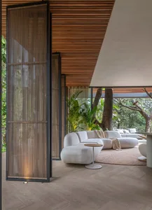 Modern interior design featuring a sleek, curved white sofa in a living room setting with a wooden floor, ceiling, and white 
