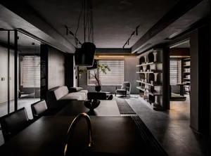 A modern living room with concrete walls, concrete chairs, and a concrete floor.
