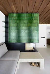 Modern living room featuring a concrete and metal furniture set and a green bamboo divider.