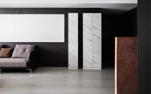 Modern living room featuring a marble floor, black accent walls, and minimalist furniture.