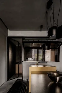 Modern minimalist kitchen featuring gray concrete surfaces and sleek black appliances.