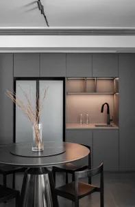 A modern minimalist kitchen with metal interiors and a sleek, geometric table setup.