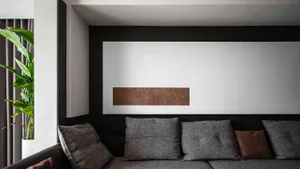 A modern, minimalist living room with a grey sectional sofa, grey throw pillows, and a minimalist interior design.