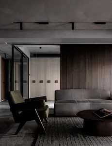 Modern minimalist living room with leather furniture, wood accents, and glass elements.