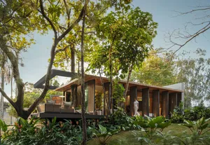 A modern residential retreat with a wooden exterior surrounded by lush greenery.
