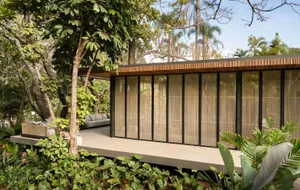 A modern residential space featuring a wooden structure and lush greenery.