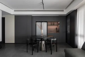 Modern, minimalist kitchen featuring a sleek black metal round table with chairs.