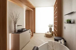 A modern minimalist bathroom featuring marble floor and walls, concrete walls, and wooden accents.
