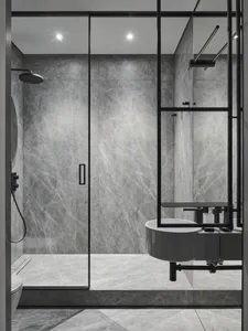 Modern bathroom with marble walls and flooring, featuring a floating sink and sleek black fixtures.