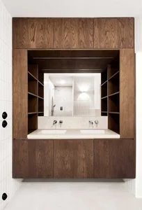 Modern bathroom featuring marble countertops and wooden cabinets.