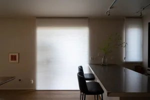 Modern kitchen with white cabinets, glass window, and metal fixtures.