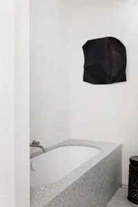 A modern bathroom with a terrazzo bathtub and minimalist design