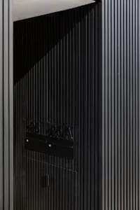 A modern building entrance with a sleek, black metal door.