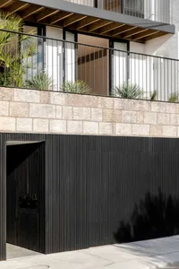Modern black architectural facade featuring stone materials and a sleek design.