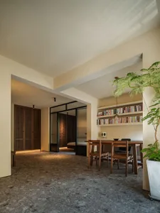 A modern dining room featuring a concrete floor and wooden furniture.