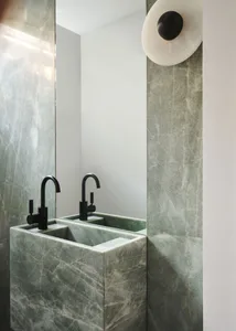 Modern bathroom with marble sink and faucets, black hardware, and a large mirror.