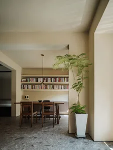 A modern dining room featuring wooden furniture and concrete accents.