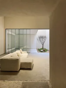 Modern interior with concrete walls, floor, and minimalist furniture, featuring a living room space with a large window and a