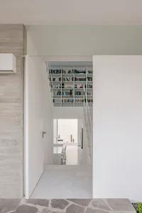 A modern interior space featuring concrete shelving filled with books.