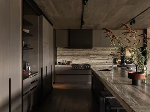 Modern residential kitchen with natural stone countertops and dark wood cabinetry.