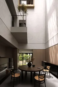Modern residential interior with minimalist design, featuring wooden furniture and glass walls.