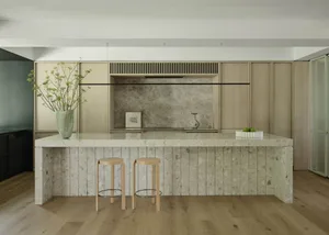 Modern kitchen with marble countertops, wood accents, and terrazzo finishes.