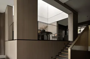 A modern minimalist interior design featuring wooden furniture and a glass table.