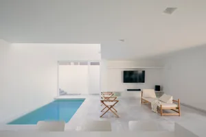Contemporary living space featuring a modern, minimalist design with white marble floors and a private pool area.