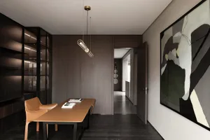 A modern home office featuring a sleek, minimalist desk with a leather surface, designed for comfort and functionality.