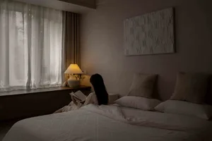 A tranquil bedroom scene featuring modern furniture and white pillows.