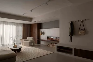 Modern minimalist living room featuring a concrete fireplace and white furniture